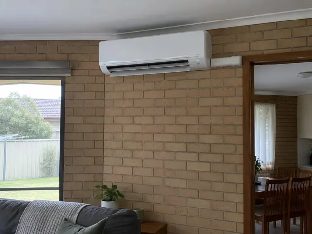 Indoor split system mounted on a brick wall in a home interior with louvre open in Elizabeth Vale